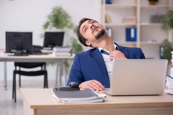 Junge männliche Angestellte unzufrieden mit exzessiver Arbeit im Büro — Stockfoto