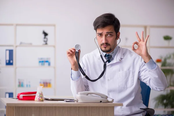 Jonge mannelijke arts werkzaam in de kliniek — Stockfoto