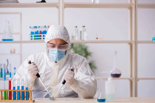 Joven químico trabajando en el laboratorio durante una pandemia — Foto de Stock