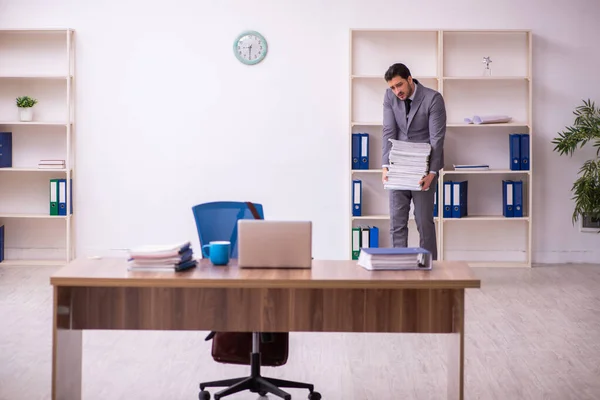 Empleado joven empresario descontento con el trabajo excesivo en la oficina — Foto de Stock