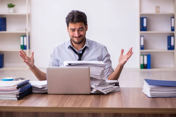 Empleado joven empresario descontento con el trabajo excesivo en la oficina — Foto de Stock