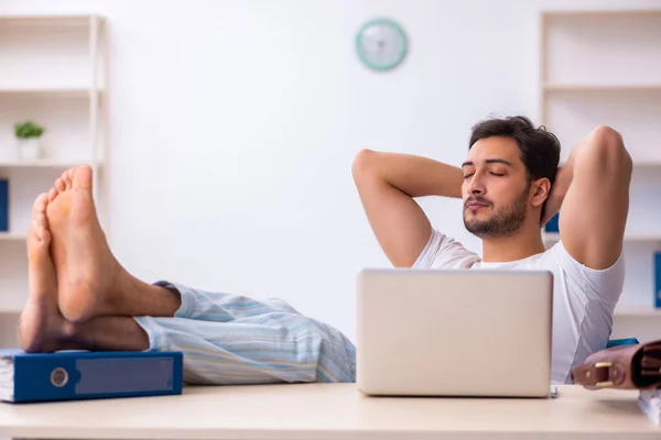 Giovane dipendente maschio che viene a lavorare direttamente dal letto — Foto Stock