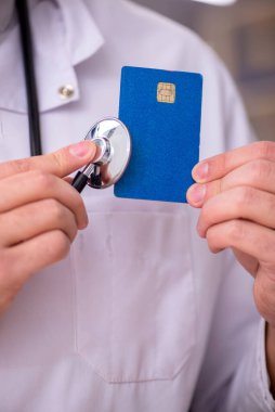 Erkek doktor kredi kartı tutuyor.