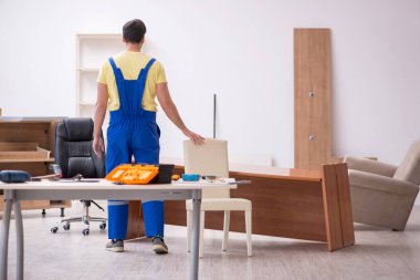 Genç erkek marangoz ofiste çalışıyor.