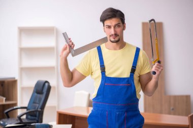 Genç erkek marangoz ofiste çalışıyor.