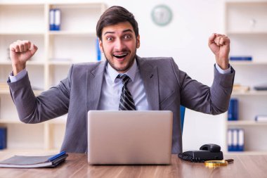 Genç yakışıklı işadamı ofiste çalışıyor.