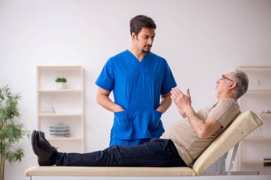 Yaşlı erkek hasta, genç doktor.