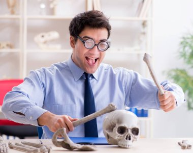 Komik çılgın profesör insan iskeletini inceliyor.