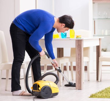 Genç adam evini temizliyor.