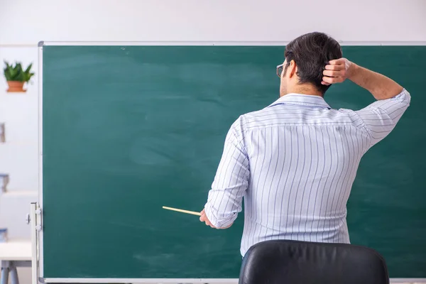 Jonge mannelijke leraar voor schoolbord — Stockfoto