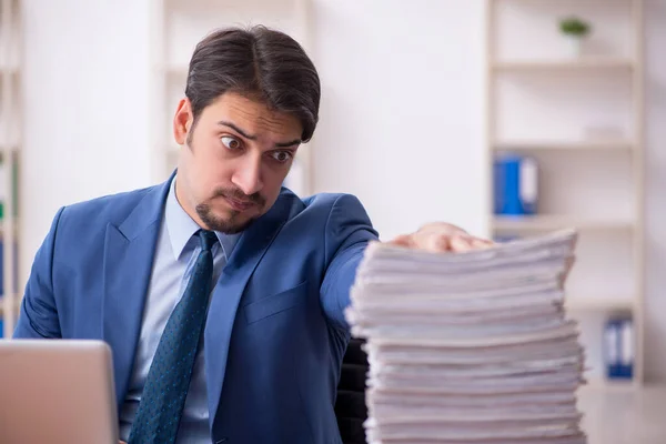 Empleado joven de negocios y demasiado trabajo en la oficina — Foto de Stock