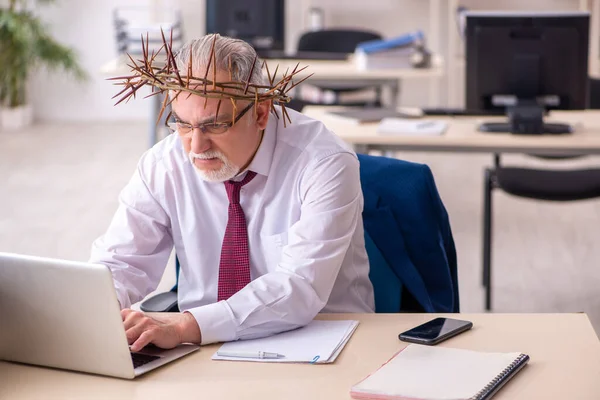 Alter männlicher Angestellter trägt stacheligen Kranz auf dem Kopf — Stockfoto