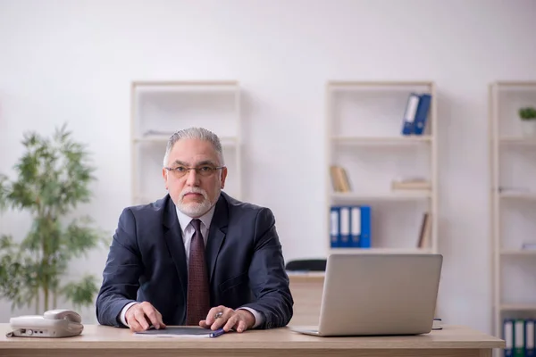 Viejo empleado sentado en el lugar de trabajo —  Fotos de Stock