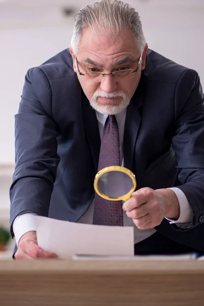 Vecchio dipendente maschile seduto sul posto di lavoro — Foto Stock