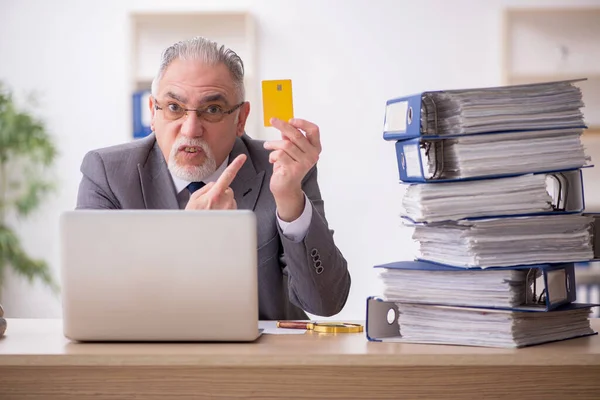 Old male employee unhappy with excessive work in the office — Stock Photo, Image