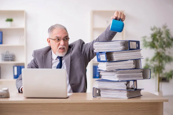Alte männliche Angestellte unzufrieden mit exzessiver Arbeit im Büro — Stockfoto