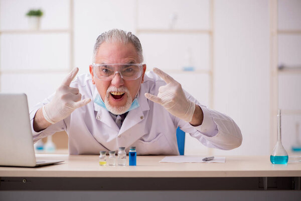 Old male chemist working in the lab during pandemic