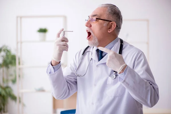 Gammal manlig läkare som arbetar på kliniken — Stockfoto