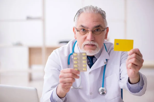 Klinikte çalışan yaşlı erkek doktor. — Stok fotoğraf