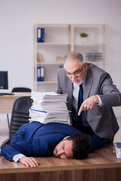 Два работника-мужчины и слишком много работы в офисе — стоковое фото