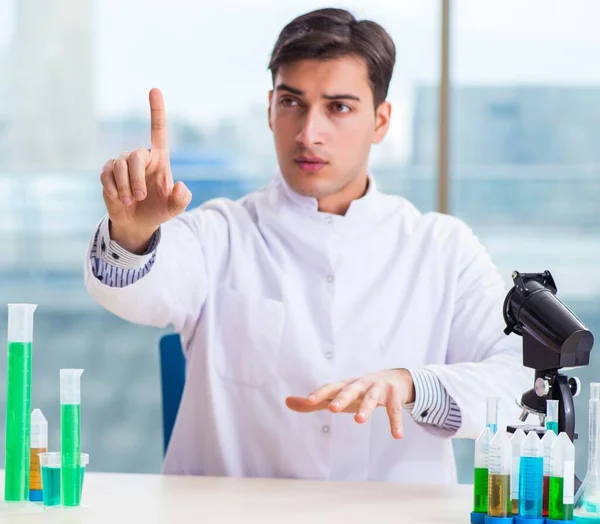 Joven químico presionando botones virtuales en el laboratorio — Foto de Stock