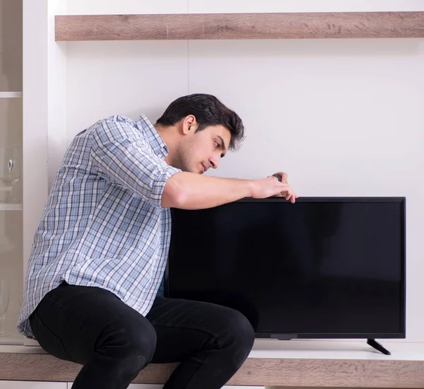 Mężczyzna naprawia zepsuty telewizor w domu — Zdjęcie stockowe