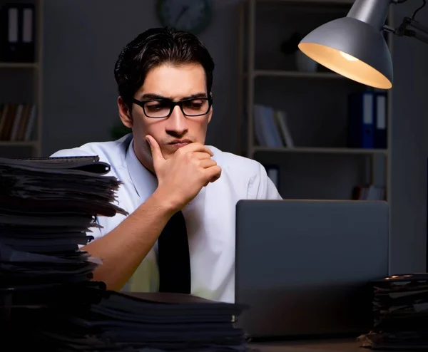 Joven hombre de negocios trabajando horas extras hasta tarde en el cargo — Foto de Stock