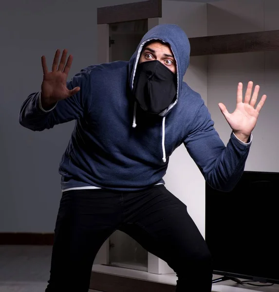 Burglar thief stealing tv from apartment house — Stock Photo, Image