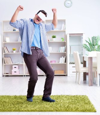 Evde sanal gerçeklik gözlüklü bir adam oynuyor.