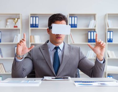 Ofiste sanal gerçeklik gözlüklü bir iş adamı var.