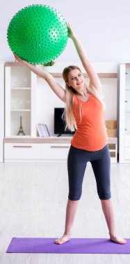 Evde doğum egzersizi yapmaya hazırlanan genç bir kadın.