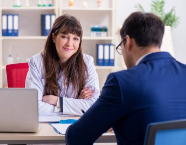 İş adamı doktorla sağlık sorunlarını tartışıyor