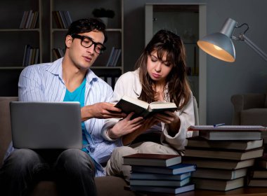 İki öğrenci geç saatlere kadar çalışıp sınavlara hazırlanıyor.