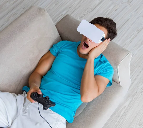 Hombre joven con gafas VR relajándose en sofá — Foto de Stock