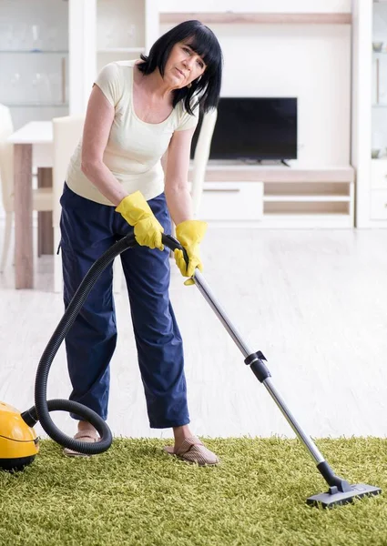 Senior oude vrouw moe na stofzuigen huis — Stockfoto