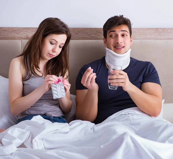 Amada esposa cuidando do marido ferido na cama — Fotografia de Stock