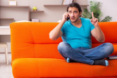 Genç erkek öğrenci salgın sırasında evde oturuyor.