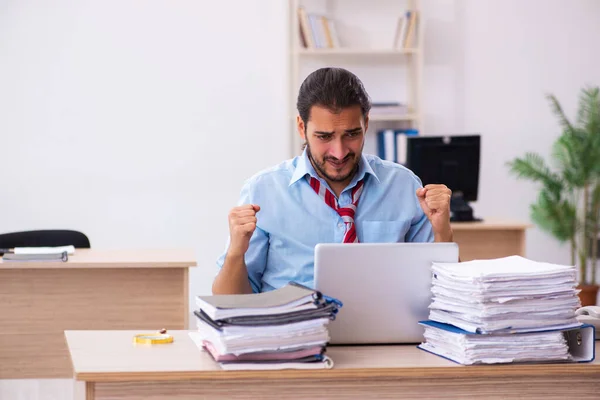 Joven empleado masculino descontento con el trabajo excesivo en la oficina —  Fotos de Stock