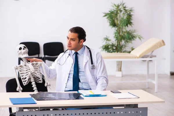 Joven doctor y paciente esqueleto en la clínica — Foto de Stock