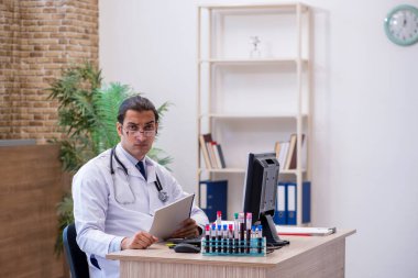 Klinikte çalışan genç bir erkek kardiyolog.