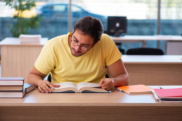 Joven estudiante masculino preparándose para los exámenes en el aula — Foto de Stock