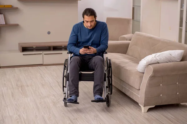 Jovem em cadeira de rodas sofrendo em casa — Fotografia de Stock