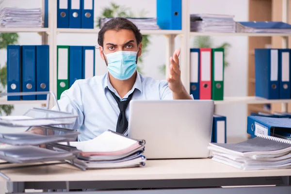 Jovem empregado do sexo masculino que trabalha no escritório durante pandemia — Fotografia de Stock