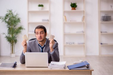 Ofiste çalışan hasta genç bir erkek.