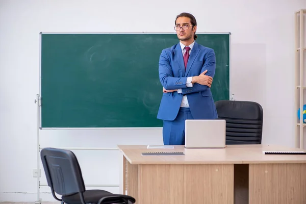 年轻的男老师穿着西服站在绿板前 — 图库照片