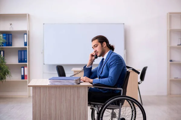 Junge männliche Angestellte im Rollstuhl bei der Arbeit im Büro — Stockfoto