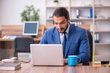 Ofiste çalışan genç bir erkek.