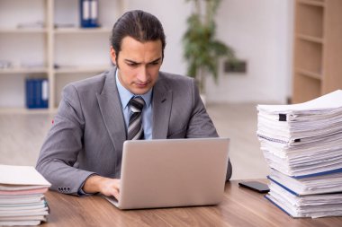 Ofisteki aşırı işten memnun olmayan genç bir erkek işçi.