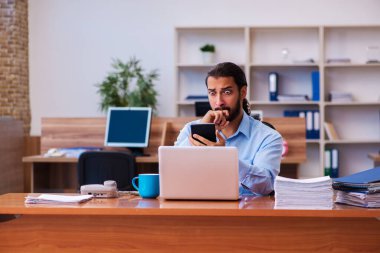 Ofiste çalışan genç bir erkek.