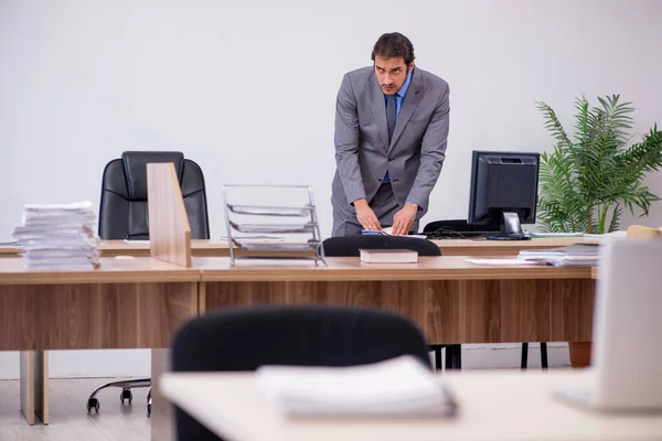 Young male employee in industrial espionage concept